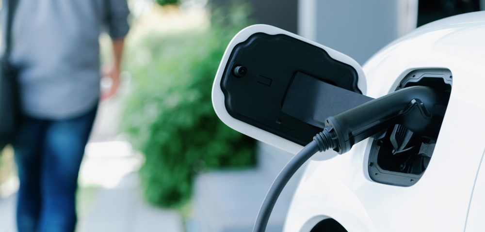 Focus,Electric,Car,Charging,At,Home,Charging,Station,With,Blurred